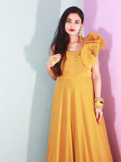 A full shot of the mustard yellow gown, showcasing its beautiful flow and contemporary design.