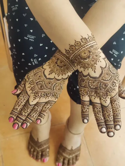 A slightly different angle of the same back-of-hand design, showing how it complements the matching foot mehendi.