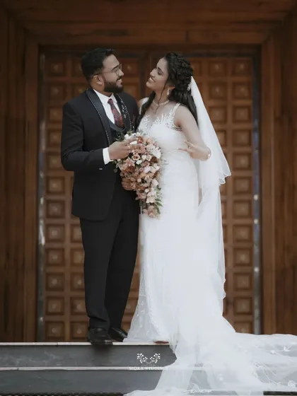 The couple sharing a sweet moment on the steps of the church, the groom looking lovingly at his bride.