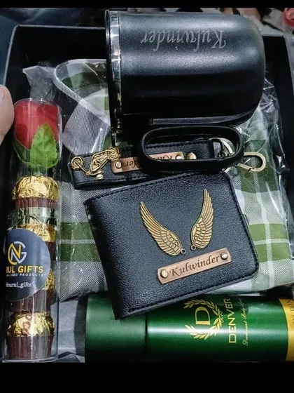 A detailed look at a packed gift hamper containing a personalized wallet, keychain, and mug, along with a shirt, deodorant, and chocolates.