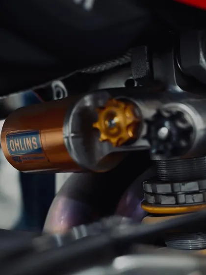 A detailed shot of the Ohlins rear shock absorber on a race bike. High-performance suspension is one of the most effective upgrades for any motorcycle.