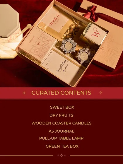 Inside the Corporate Premium hamper: a sweet box, dry fruits, a journal, a pull-up table lamp, and more. It's a thoughtful collection of festive and useful items.