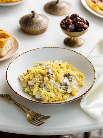 A creamy fusilli pasta with chicken and mushrooms for The Big Chill Cafe UAE. The bright, high-key lighting creates a fresh and clean look.