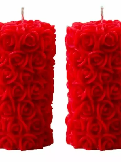 A pair of vibrant red rose pillar candles. The deep color and detailed texture make them a bold decorative statement, perfect for festive occasions.