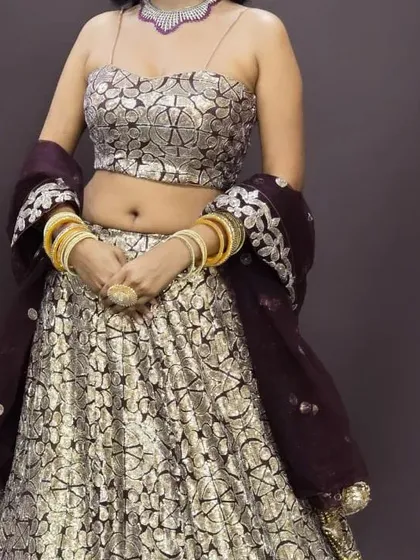 A full view of the silver patterned lehenga with a spaghetti-strap bustier. This is a stylish and modern outfit for any party.