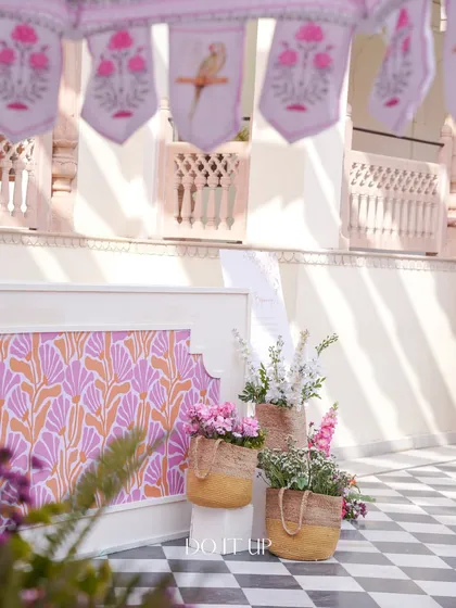A detailed shot from the Jaipur welcome lunch. It shows custom-printed fabric panels and baskets of flowers, highlighting the blend of traditional patterns and fresh florals.