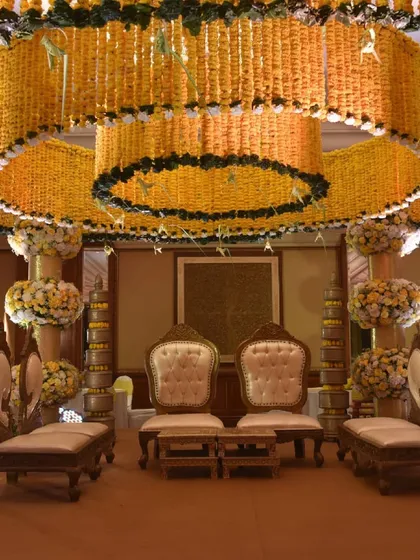 For this indoor wedding, we brought traditional grandeur to life with a magnificent mandap crafted from marigolds. The tiered canopy structure, built around the ballroom's chandelier, creates a warm, golden glow, perfect for sacred Hindu wedding rituals.