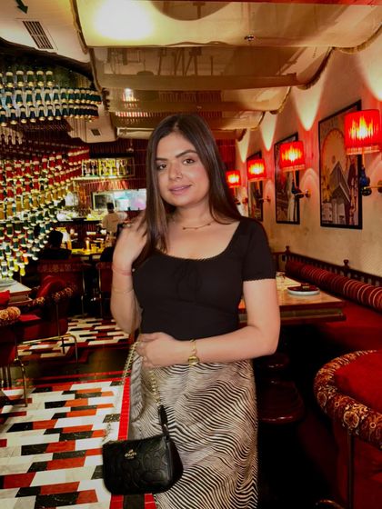 A dinner look featuring the same versatile satin skirt, paired with a simple black top for a more evening-appropriate vibe.