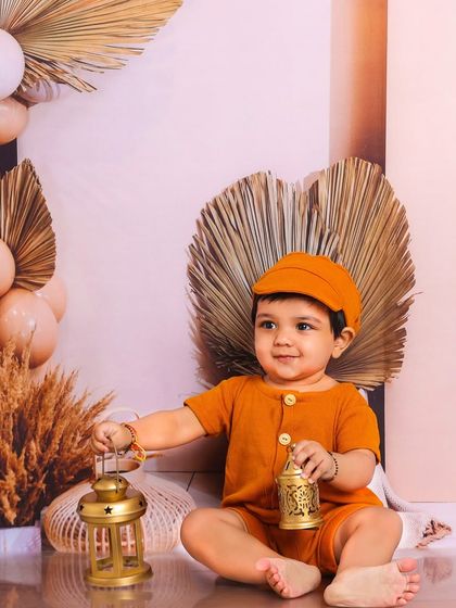 This little boy in our boho-themed set is holding lanterns, looking dapper and sweet in his mustard-colored outfit.