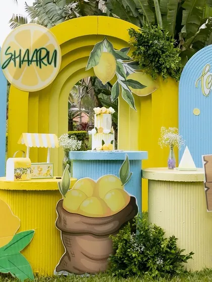 A closer look at the main dessert station for the lemonade party, with the cake perfectly centered between two arched backdrops.