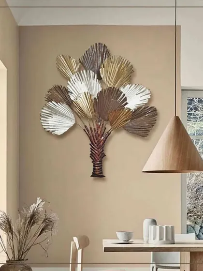 This sophisticated tree sapling wall decor features multi-colored leaves in muted, earthy tones. Made of imported engineered birch wood and metal, it adds a touch of modern, organic style to a dining room or study area.