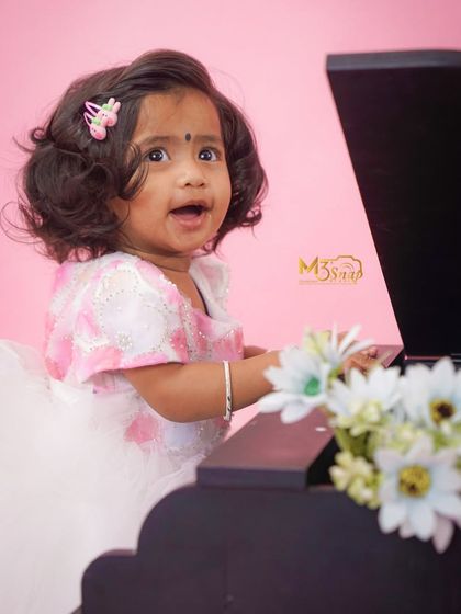 A moment of pure delight. The little girl's happy expression as she plays the piano makes for an absolutely precious and lively portrait.