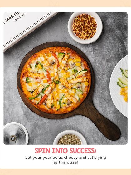 An overhead view of our fully loaded veggie and paneer pizza, surrounded by chili flakes and oregano. It's a cheesy and satisfying meal perfect for sharing.