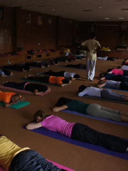 A class rests in Makarasana (Crocodile Pose) during a throwback TTC session. This pose is a gentle way to relax the back and prepare for back-bending asanas.