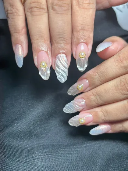 A unique set of clear extensions with a 3D wavy texture and gold pearl accents, creating a modern and artistic look.