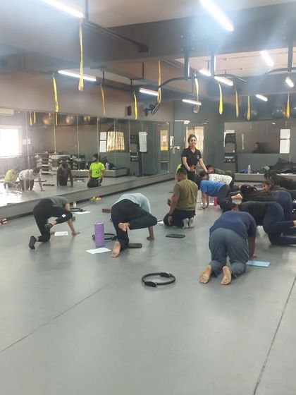Students practice a quadruped core exercise, learning how to cue and correct for proper spinal alignment.