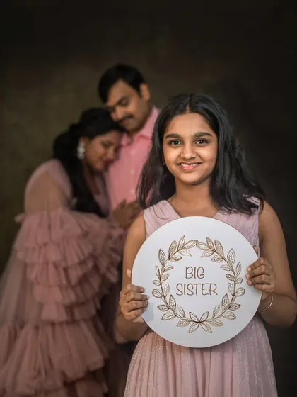 The joy of a growing family is a story in itself. This portrait, with the older daughter proudly announcing her promotion to "Big Sister," is one of those heartwarming moments that I feel so honoured to capture.