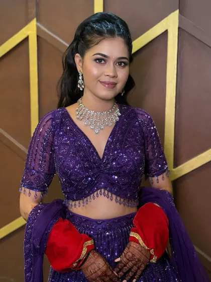 A reception look in a vibrant purple lehenga, with a simple diamond necklace.