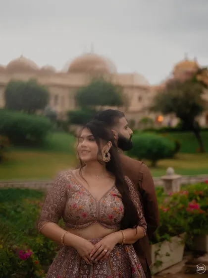 A soft, dreamy portrait with a creative blur effect, placing the focus on the bride's joyful expression during her Udaipur pre-wedding shoot. The palace backdrop adds a touch of fairytale magic.