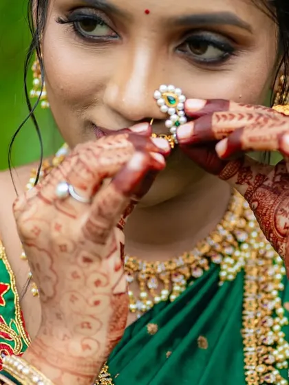 A close-up shot focusing on the rich stain of the baby shower mehendi, beautifully complementing the bride's traditional nose ring and jewelry.