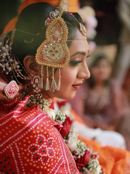 A side profile showcasing the intricate details of the traditional head jewellery and the neat bridal updo.