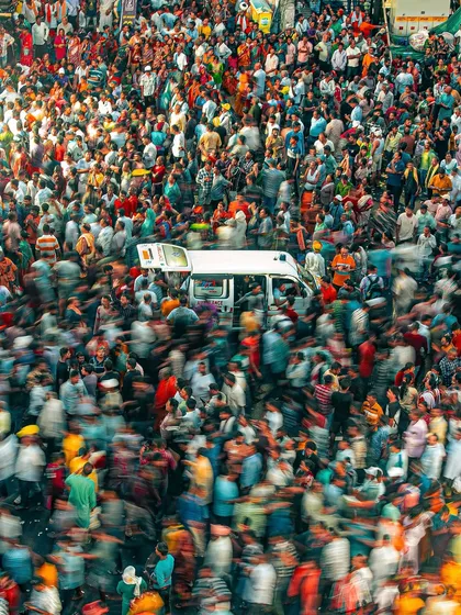 An ambulance making its way through the massive crowd at the Rath Yatra. This long-exposure shot captures the motion and stillness of the moment, a river of humanity parting for a moment of urgency.