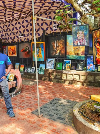 A proud moment, standing at my stall during the KALAPARBA art event. My paintings are displayed for everyone to see, featuring a mix of animal portraits, spiritual art, and cultural pieces.