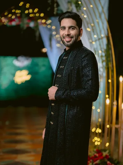 A portrait of the groom, Kartik, looking dapper and confident in his intricately designed black sherwani for his Sangeet.