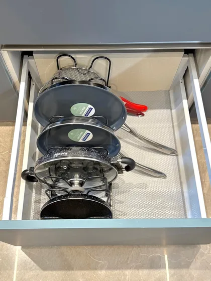 A vertical rack for pans is one of the best ways to utilize a deep drawer. It prevents scratches and makes it easy to grab the exact pan you need.