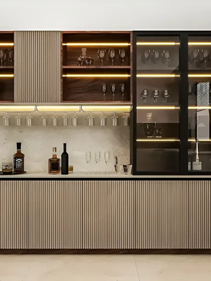 An elegant home bar and crockery unit designed for entertaining. This piece features fluted paneling, glass-front cabinets with internal lighting to showcase glassware, dedicated wine racks, and a marble-finish countertop for serving.