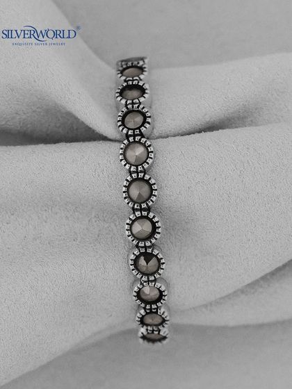 A vintage-style silver ring with a series of connected, marcasite-studded circular motifs. This eternity band has a unique, antique feel.