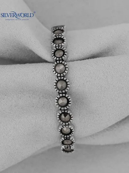 A vintage-style silver ring with a series of connected, marcasite-studded circular motifs. This eternity band has a unique, antique feel.
