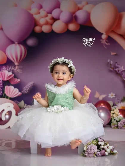 Celebrating her first birthday in style with a beautiful floral and balloon setup. This little princess is ready for her sweet and smashing moment.