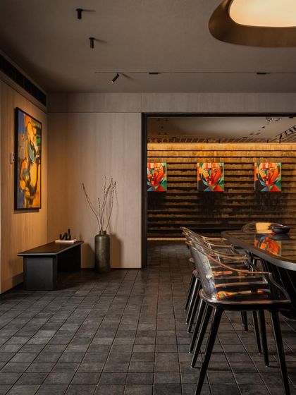 A moody corridor in a retail space uses dramatic lighting to highlight art and create a sense of journey and discovery.