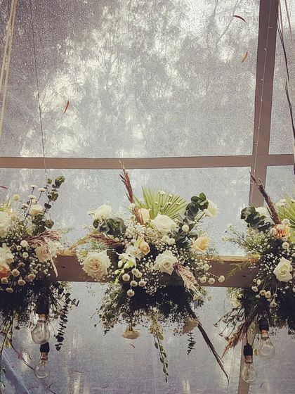 Another view of our custom-made floral chandeliers. These installations are perfect for adding a focal point to a rustic or industrial-chic event, blending natural beauty with modern lighting.