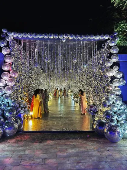 We make entrances that stop you in your tracks. This Sangeet night began with a walk through a tunnel of shimmering silver and disco balls, creating an immersive experience that instantly set a glamorous, party-ready vibe.