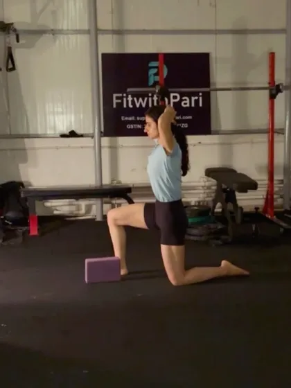 A kneeling hip flexor stretch with an overhead reach. Using a yoga block under the knee provides support and allows for a deeper stretch.