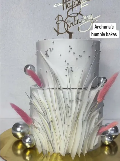 A modern two-tiered cake with a white feathery texture made from wafer paper.
