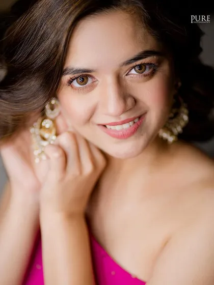 A close-up portrait of the bride, capturing her beautiful smile and elegant earrings. A perfect shot from her Mehndi ceremony.