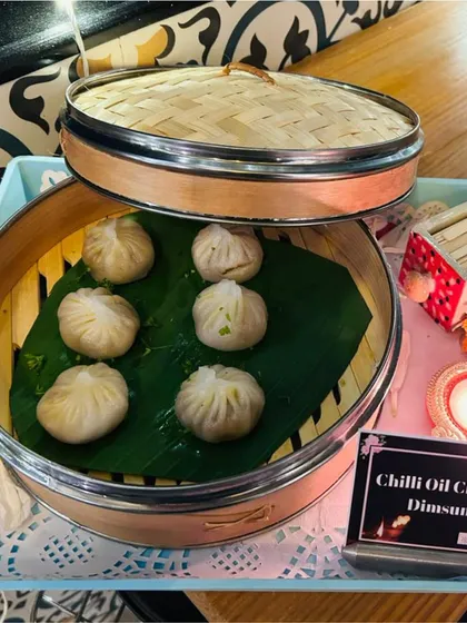 Chilli Oil Chicken Dimsums presented in a traditional bamboo steamer. This authentic presentation not only looks great but also keeps the dimsums warm and moist.