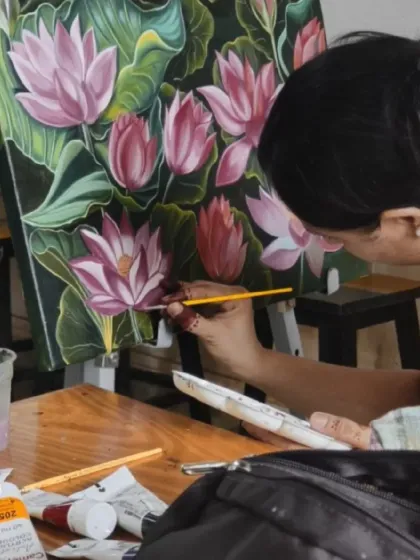Here is the artist, Priyanka, at work on her large canvas. This image captures the focus and precision required for large-scale floral paintings, a popular subject in our hobby and advanced courses.