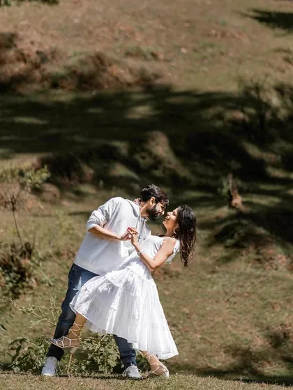 A playful dance in a sunlit meadow. This shot is full of life and movement, capturing the fun and carefree side of the couple's relationship in a beautiful outdoor location.
