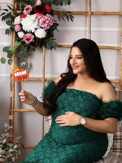A sweet "Mom to be" prop adds a fun element to this beautiful solo portrait in the green gown.