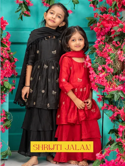 For a bold and beautiful statement, I love pairing classic colors like red and black. This sister duo is ready for any grand occasion in these striking tiered sharara sets, featuring delicate embroidery that adds a touch of sparkle to the rich, solid colors.
