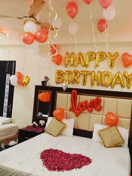 A different angle of the love-themed birthday surprise, showing the arrangement of balloons hanging from the ceiling with ribbons.