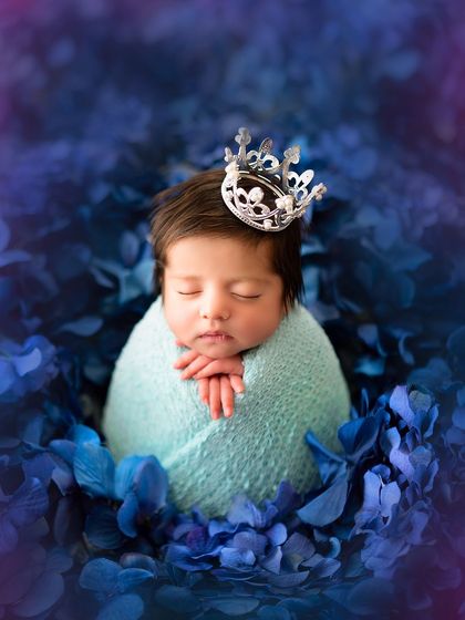 Every princess deserves her crown. This close-up of a sleeping newborn with a tiny, delicate crown is a simple yet powerful portrait.