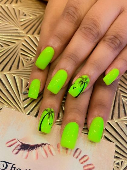 Get ready for a vacation with these neon green nails. The square-shaped set features accent nails with hand-painted black palm trees for a tropical vibe.