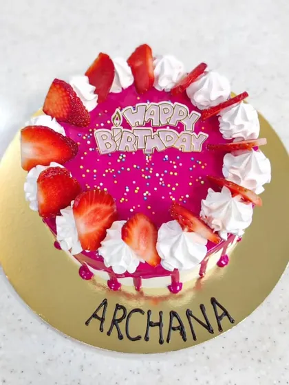 A vibrant fresh strawberry cake. The bright pink glaze and fresh strawberry slices make this a light, fruity, and delicious option for a birthday celebration.