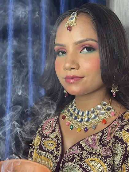 A photo of a recreated glam makeup look inspired by a famous artist, featuring a smoky effect and colorful eyes.