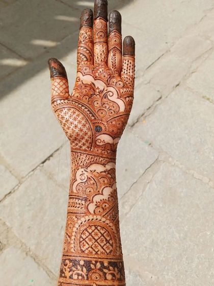 This is a full bridal mehendi I practiced on myself, inspired by one of my favorite artists. It features cloud-like swirls, intricate netting, and varied finger designs, covering the hand and arm completely.